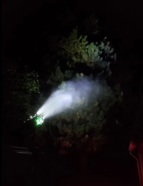 Intervention nocturne d'élagage avec nacelle élévatrice dans un environnement urbain arboré