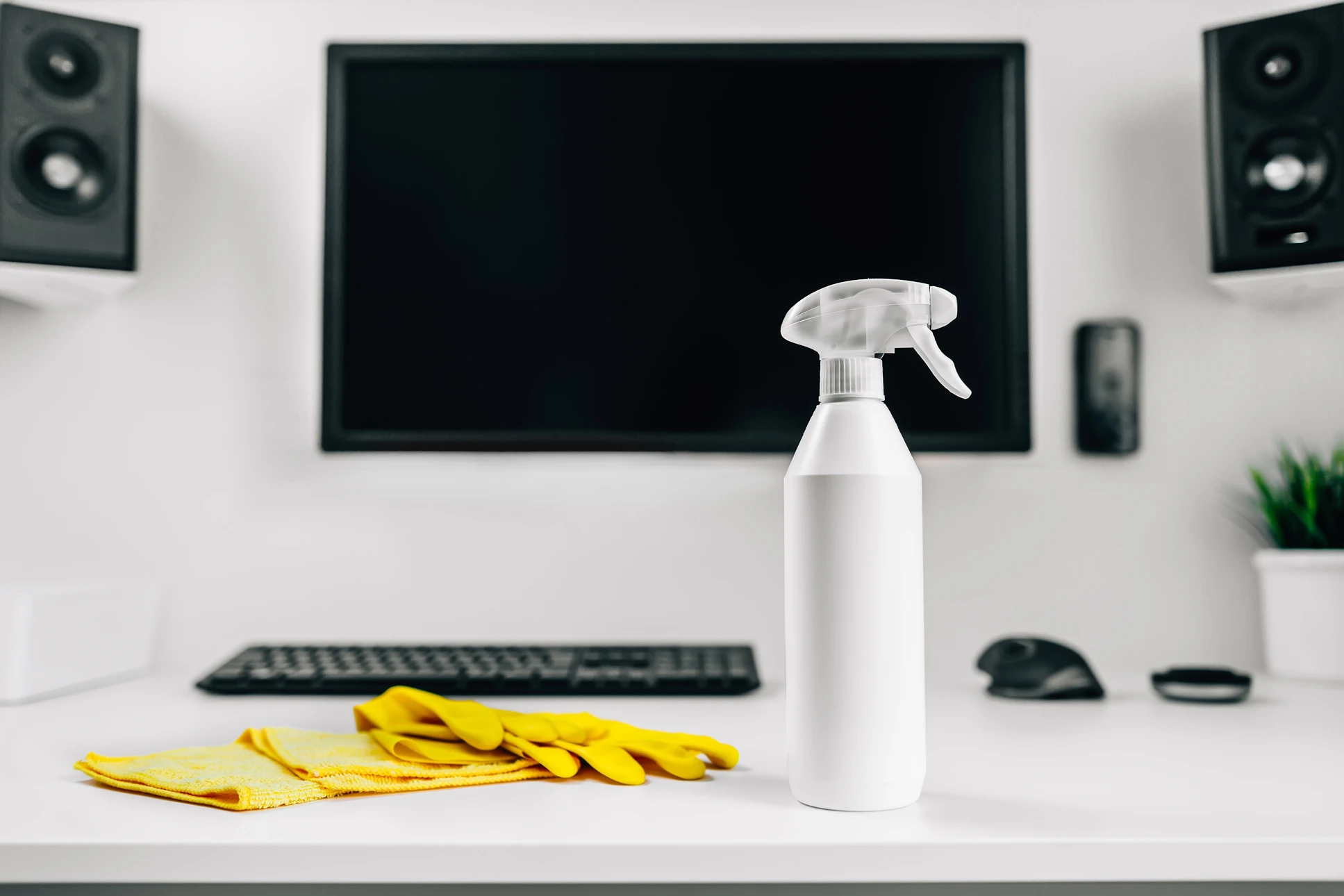Espace de travail de bureau avec produits de nettoyage professionnel disposés sur un plan de travail blanc